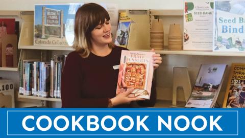Woman holding cookbook in a library