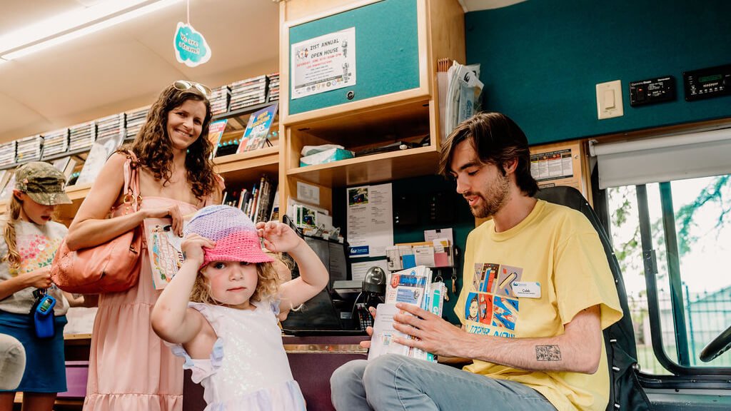 Parent with child on a bookmobile.