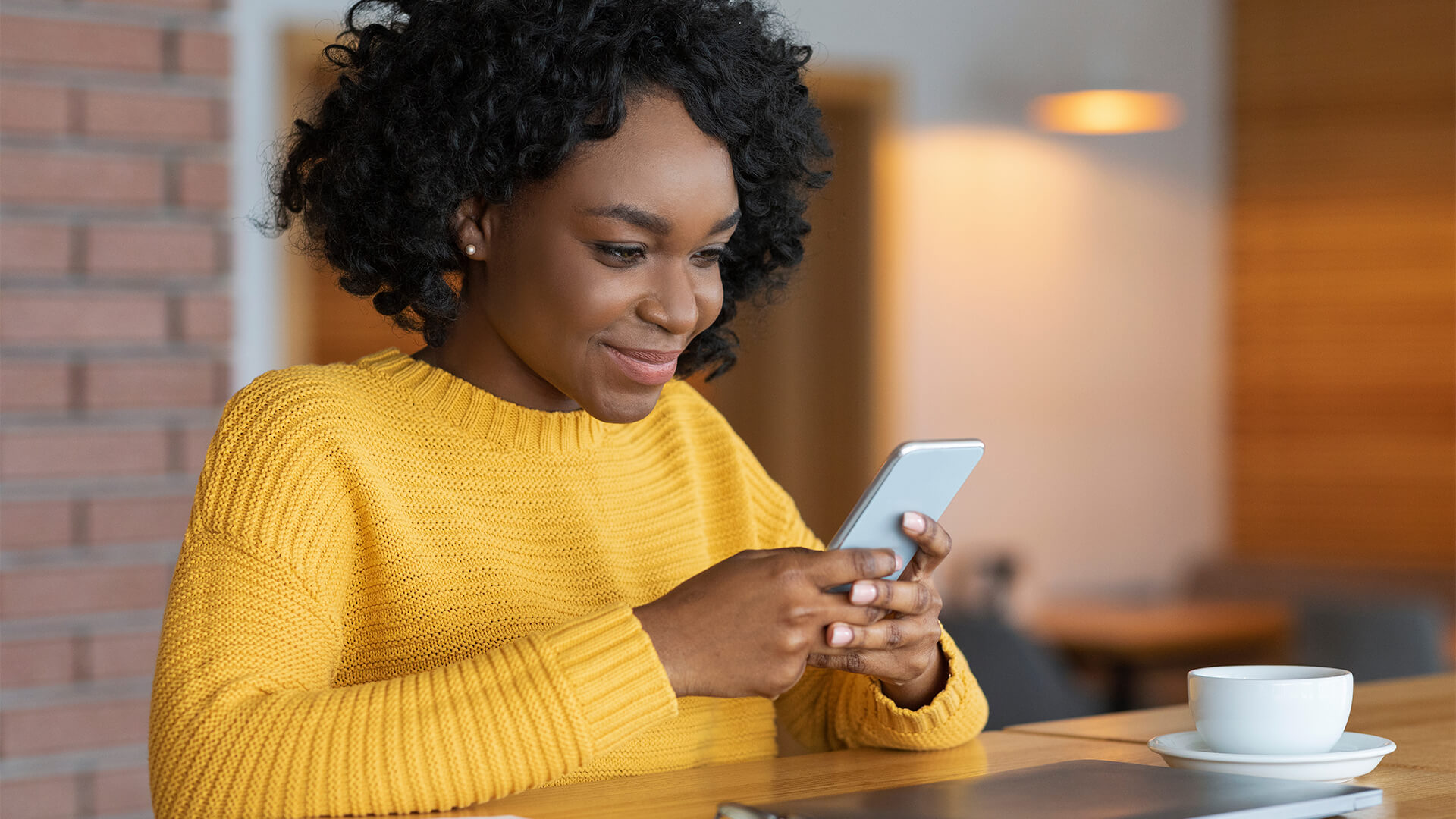 Woman texting while having coffee